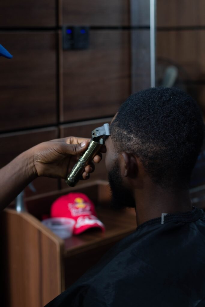Close-up of a man receiving a haircut in a modern barbershop setting.